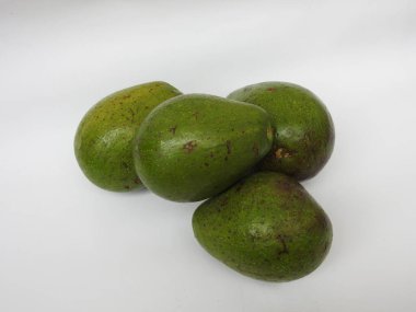 Çiğ tereyağlı meyve veya avokadodan oluşan tek ve yarı dilimlenmiş ve beyaz arka planda izole edilmiş meyveleri tutan bir grup yakın plan.