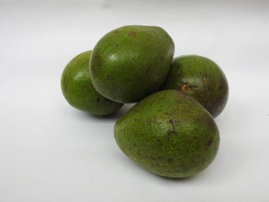 Çiğ tereyağlı meyve veya avokadodan oluşan tek ve yarı dilimlenmiş ve beyaz arka planda izole edilmiş meyveleri tutan bir grup yakın plan.