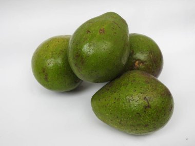 Çiğ tereyağlı meyve veya avokadodan oluşan tek ve yarı dilimlenmiş ve beyaz arka planda izole edilmiş meyveleri tutan bir grup yakın plan.