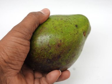 Çiğ tereyağlı meyve veya avokadodan oluşan tek ve yarı dilimlenmiş ve beyaz arka planda izole edilmiş meyveleri tutan bir grup yakın plan.