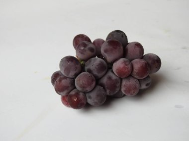 Güzel koyu kırmızı ve siyah üzüm meyvelerinin yakın plan resmi beyaz arka planda izole edilmiş.