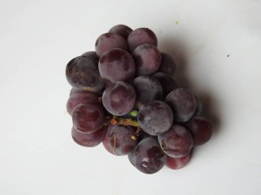 Güzel koyu kırmızı ve siyah üzüm meyvelerinin yakın plan resmi beyaz arka planda izole edilmiş.