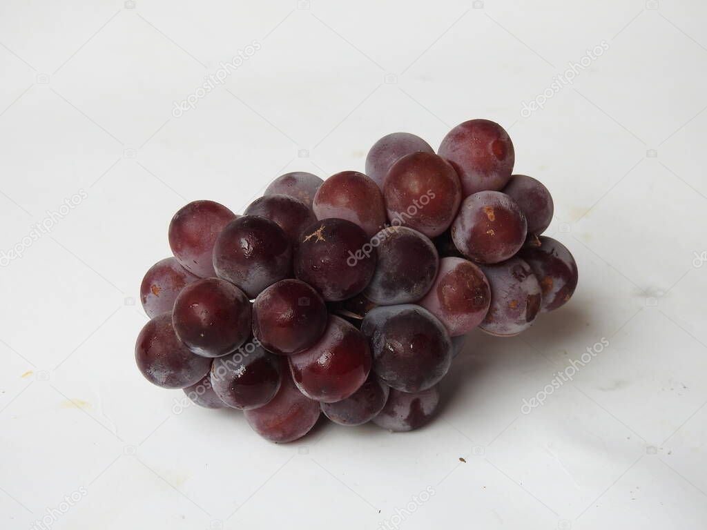 Closeup of beautiful dark red and black color grape fruits bunch isolated on white background