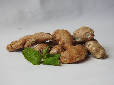 Group of Spice and Medicinal Fresh ginger rhizome with green leaves isolated on white background.