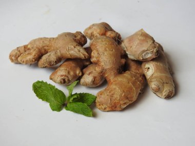 Group of Spice and Medicinal Fresh ginger rhizome with green leaves isolated on white background.