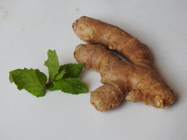 Group of Spice and Medicinal Fresh ginger rhizome with green leaves isolated on white background.