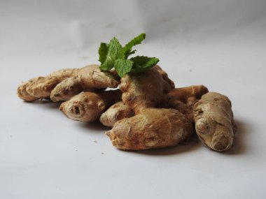 Group of Spice and Medicinal Fresh ginger rhizome with green leaves isolated on white background.