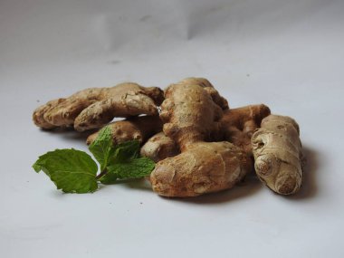 Group of Spice and Medicinal Fresh ginger rhizome with green leaves isolated on white background.