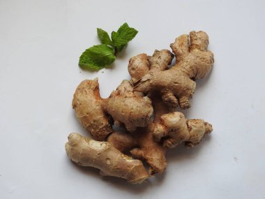 Group of Spice and Medicinal Fresh ginger rhizome with green leaves isolated on white background.