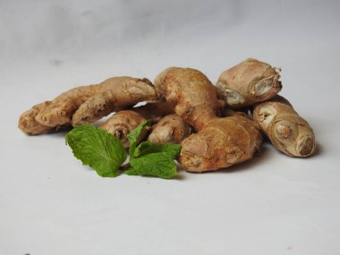 Group of Spice and Medicinal Fresh ginger rhizome with green leaves isolated on white background.