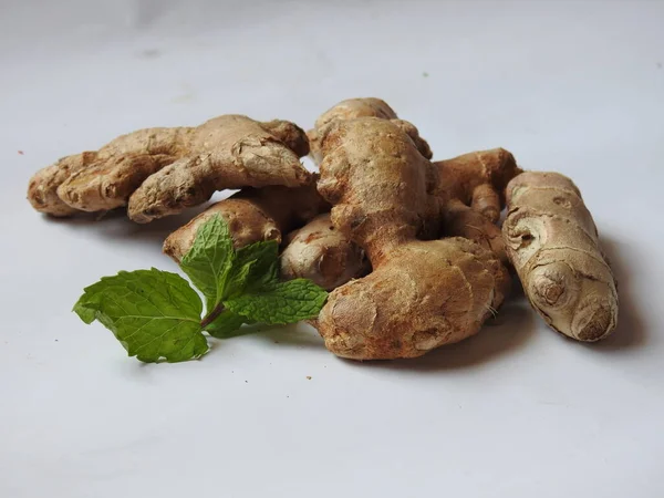 Group of Spice and Medicinal Fresh ginger rhizome with green leaves isolated on white background.