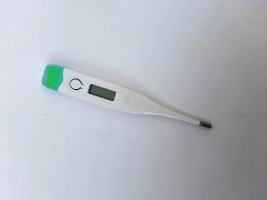 Beyaz ve yeşil dijital kapaklı plastik termometreye yakın plan beyaz zemin