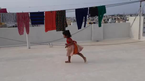 2021年4月25日 印度卡纳塔克邦班加罗尔 印度小女孩在建筑用布的阳台上玩耍时被晒得干干净净 — 图库视频影像