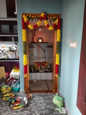 Bangalore, Karnataka, Hindistan-Haziran 01-2021: Gruha Pravesham nedeniyle çelenk ve çiçeklerle süslenmiş yeni inşa edilmiş Puja Odası ve Mutfağı.