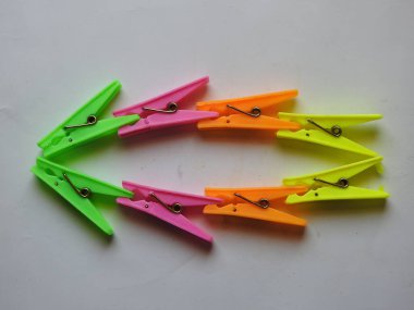 Beyaz arkaplanda izole edilmiş kumaş asılı plastik kliplerin çeşitli renk arkaplan yakın plan