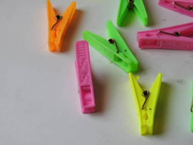 Beyaz arkaplanda izole edilmiş kumaş asılı plastik kliplerin çeşitli renk arkaplan yakın plan