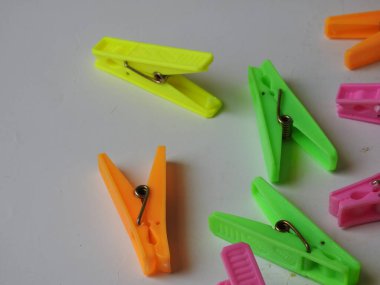 Beyaz arkaplanda izole edilmiş kumaş asılı plastik kliplerin çeşitli renk arkaplan yakın plan