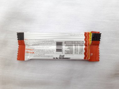 Bangalore, Karnataka, Hindistan-Aug 10-2021: Kağıt Teknesi Chikki veya Fıstık Çubuğu Paketinin Kapanışı Eklenmemiş Koruyucu ve Renkler beyaz arkaplanda izole edildi