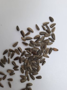 Yığın yığını ve siyah renkli ay çekirdeği yığınının yakın plan beyaz arkaplanda kabuk dokusu izole