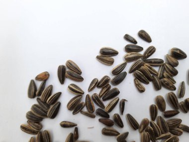 Yığın yığını ve siyah renkli ay çekirdeği yığınının yakın plan beyaz arkaplanda kabuk dokusu izole