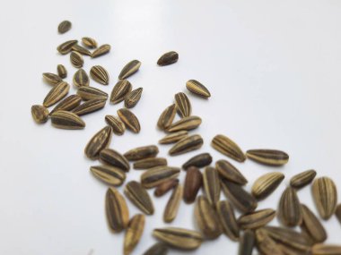 Yığın yığını ve siyah renkli ay çekirdeği yığınının yakın plan beyaz arkaplanda kabuk dokusu izole