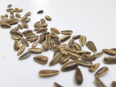 Yığın yığını ve siyah renkli ay çekirdeği yığınının yakın plan beyaz arkaplanda kabuk dokusu izole