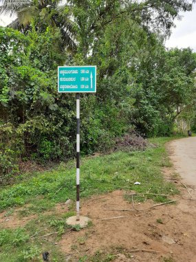 Mandya, Karnataka, Hindistan-Sep 10 2021: Hindistan köy yollarının kapatılması ve Kırsal Kalkınma ve Panchayat Raj Hükümeti Otobüs durağı inşaatı hakkında bilgi panosu, beyaz tepeli yollar