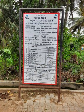 Mandya, Karnataka, Hindistan-Sep 10 2021: Hindistan köy yollarının kapatılması ve Kırsal Kalkınma ve Panchayat Raj Hükümeti Otobüs durağı inşaatı hakkında bilgi panosu, beyaz tepeli yollar