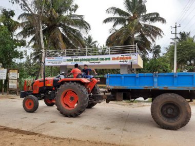 Mandya, Karnataka, Hindistan-Sep 10 2021: Köy otobüs durağının önündeki doğa arka planına sahip traktör kapanışı