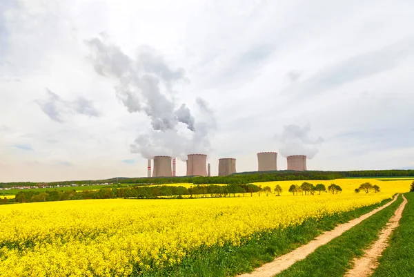 Thermal power plant with rapeseed field Royalty Free Stock Photos
