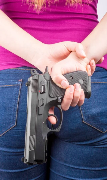 As costas de uma mulher com uma pistola na mão — Fotografia de Stock
