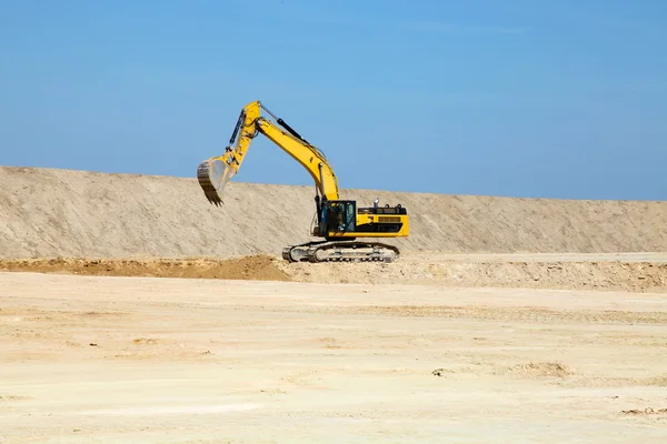  Mavi gökyüzüne karşı bir inşaat alanında sarı kazıcı