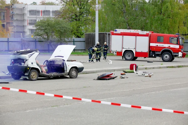 Tjeckien, Plzen, 30 September, 2015: simulering av en bilolycka. Brandmän och räddningsarbetare hjälper skadad person av bilolyckan. — Stockfoto