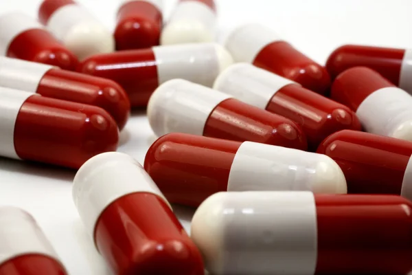 Bliska czerwone kapsułki medyczny na białym tle — Zdjęcie stockowe