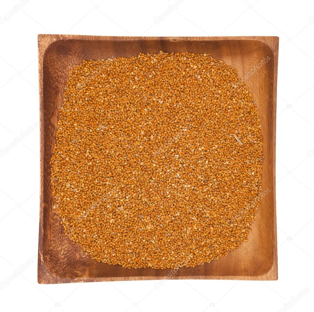 Millet in a wooden bowl on white background