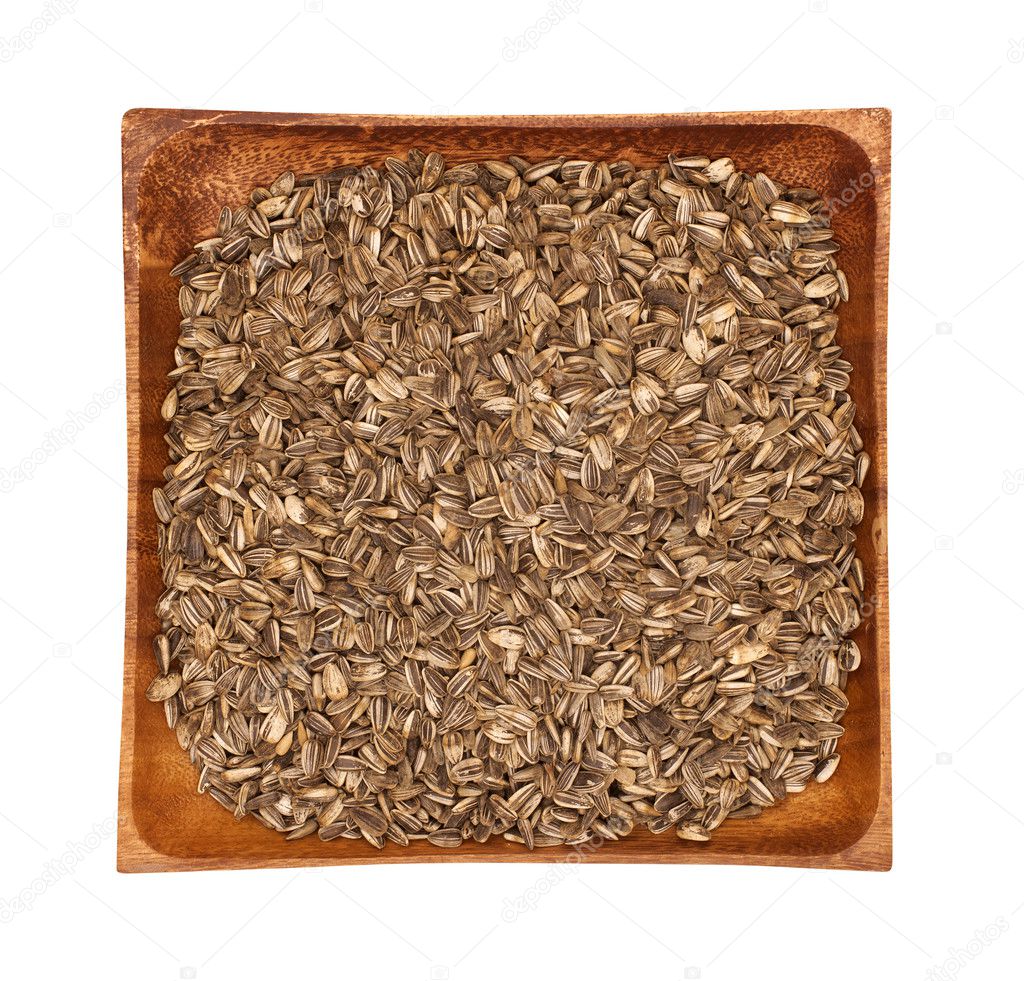 Sunflower seeds in a wooden bowl on a white background