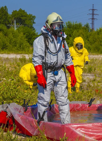 Członkowie zespołu Hazmat sobie kombinezony ochronne wobec ochraniać im z materiałów niebezpiecznych — Zdjęcie stockowe