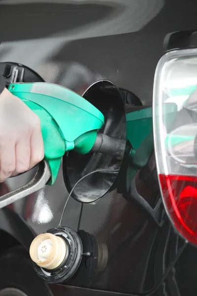 Male hand refilling the black car with fuel on a filling station — Stock Photo, Image