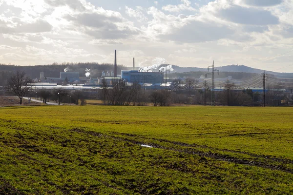 Fabriken, gröna fält och mulen himmel — Stockfoto