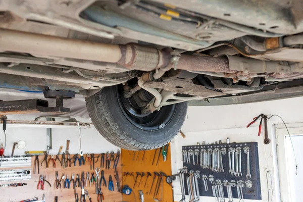 Auto service shop has lift for easy working on underside of car — Stock Photo, Image