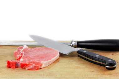 Çiğ domuz eti ve kesme tahtası üzerinde bıçaklar