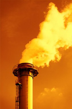Dense smoke from a chimney, sunset sky