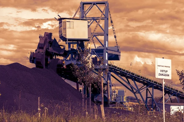 Een gigantische wiel graafmachine in brown kolenmijn in de zonsondergang — Stockfoto