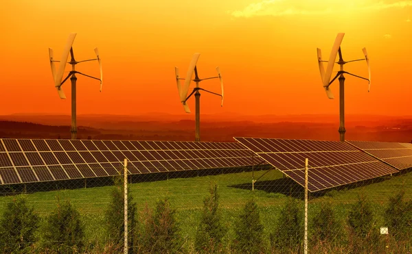 Solar panels with small wind turbines in the sunset — Stock Photo, Image