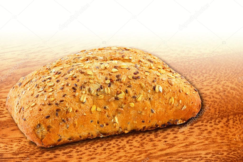 Wholemeal bread with sesame seeds on wooden background