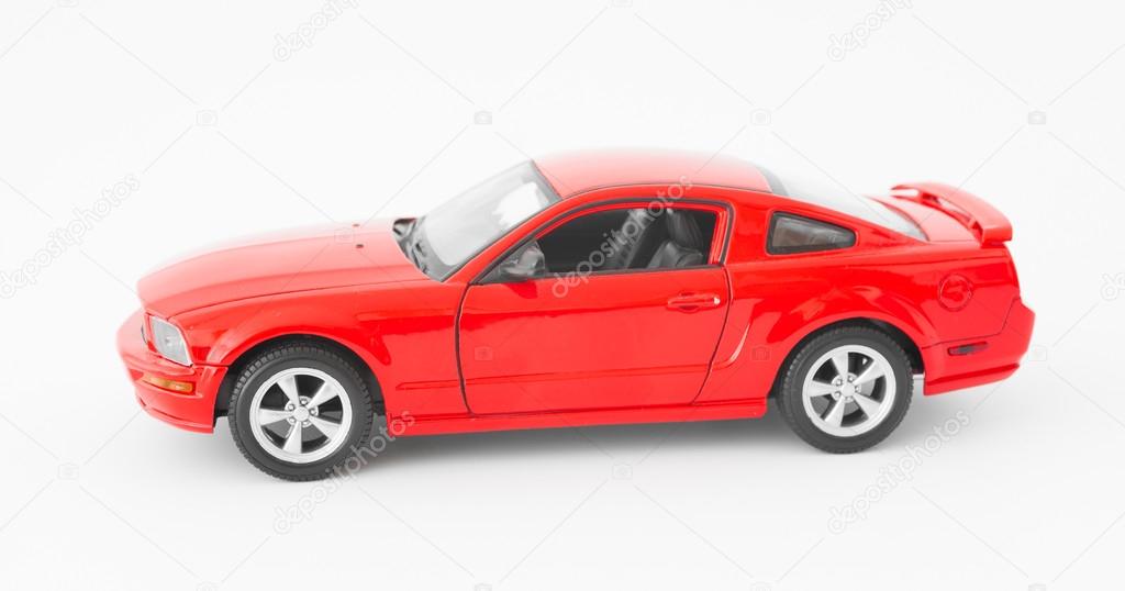 Red sports car miniature on white background
