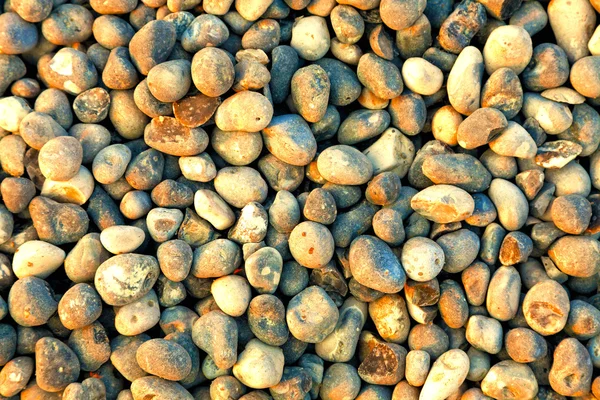 Pebbles on the beach as background — Stock Photo, Image
