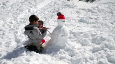 kardan adam ile birlikte oynayan iki kardeş