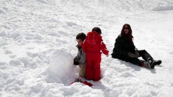 雪玉で遊ぶ 2 人の子供と母 — ストック動画