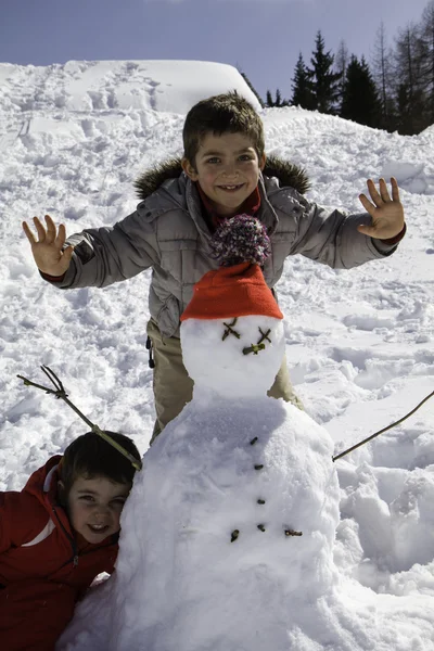 Two brothers with snowman — Stock Photo, Image